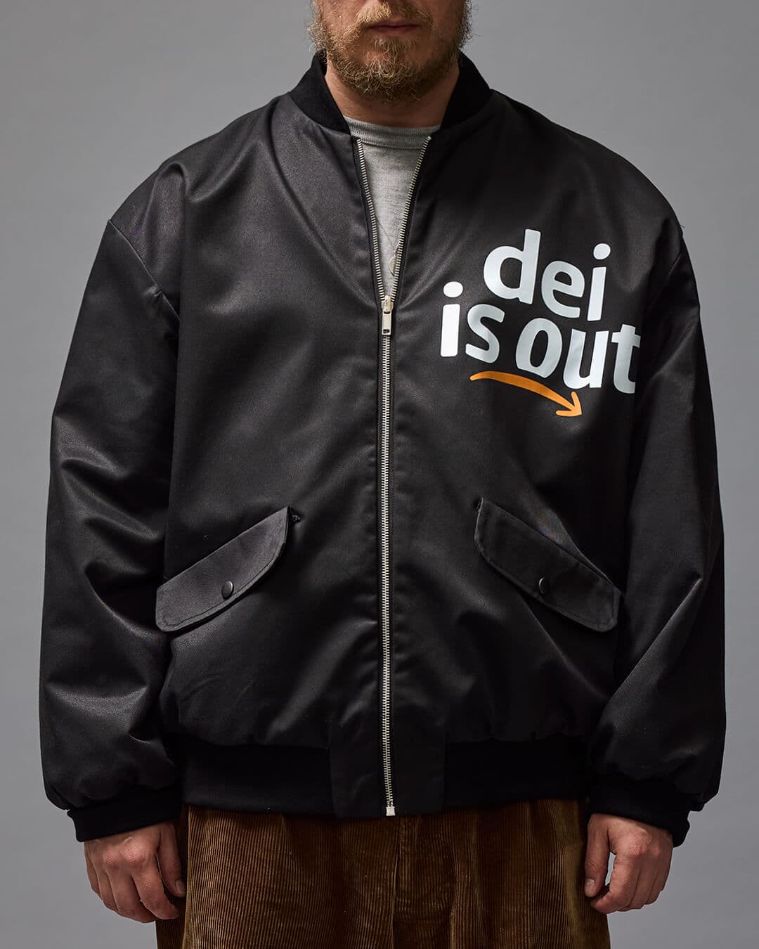 'DEI OUT' Musta bomber -tyylinen takki kuvattuna mallin päällä.