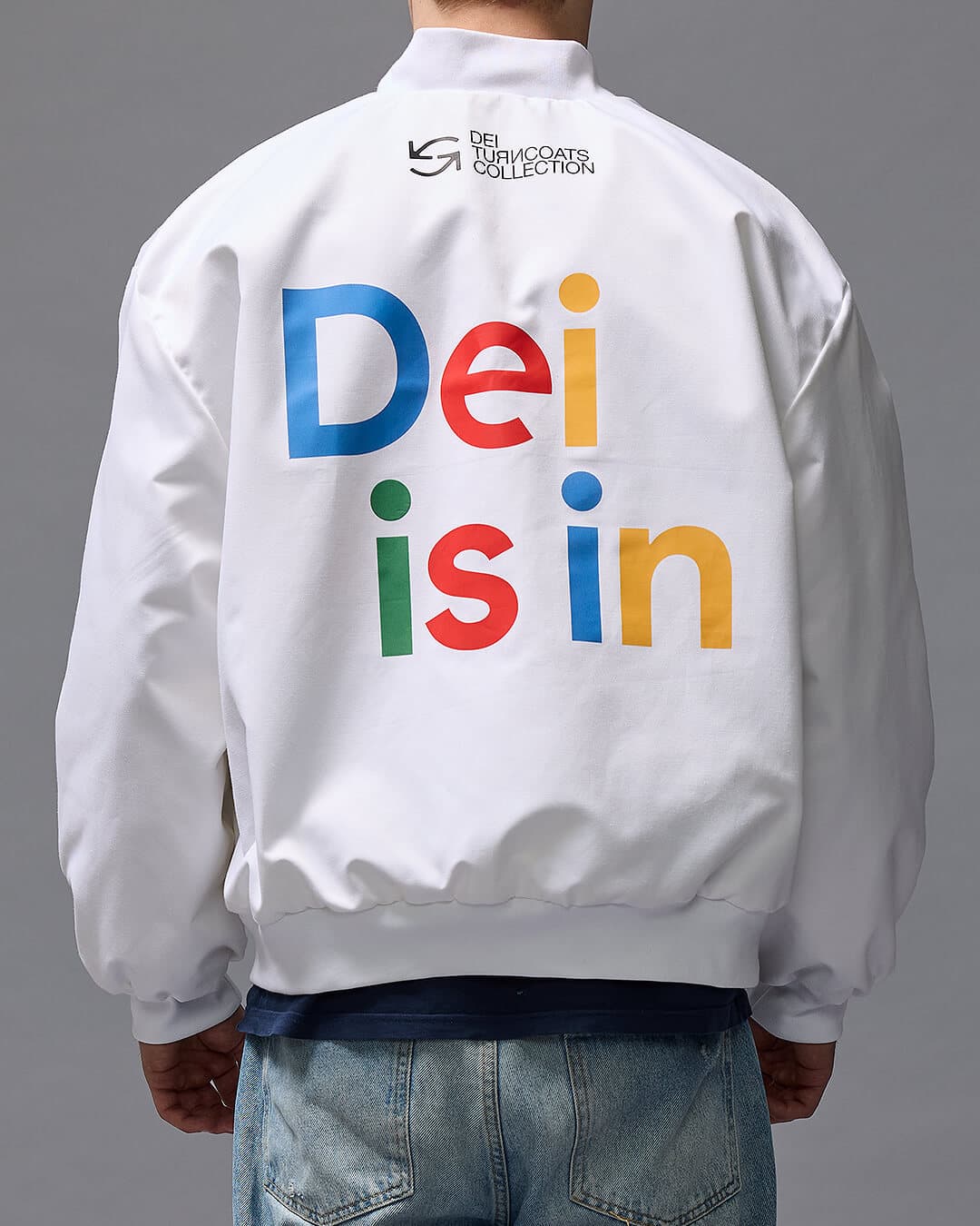 'DEI IN' Musta bomber -tyylinen takki kuvattuna mallin päällä.